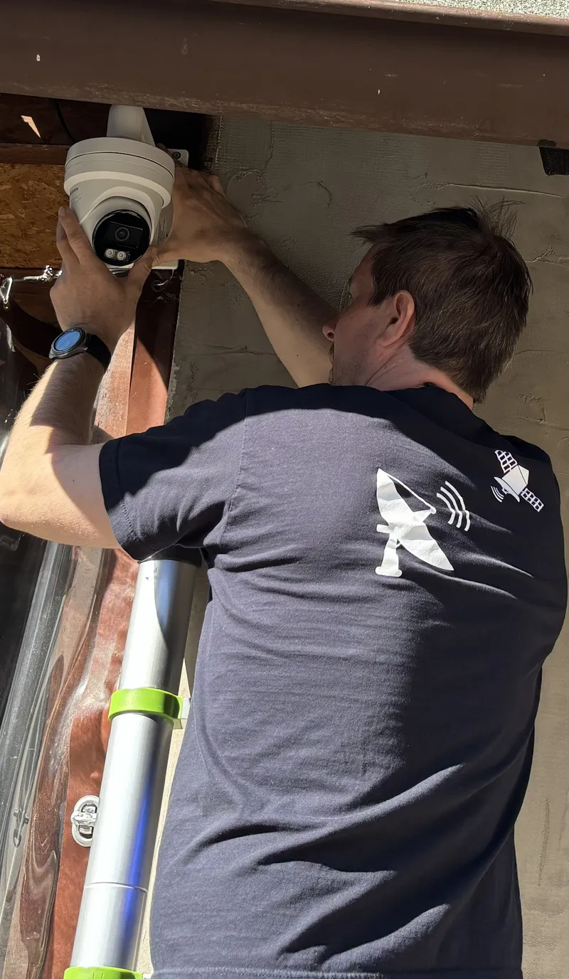 Martin Krejčí montuje bezpečnostní kameru Hikvision na zeď rodinného domu
